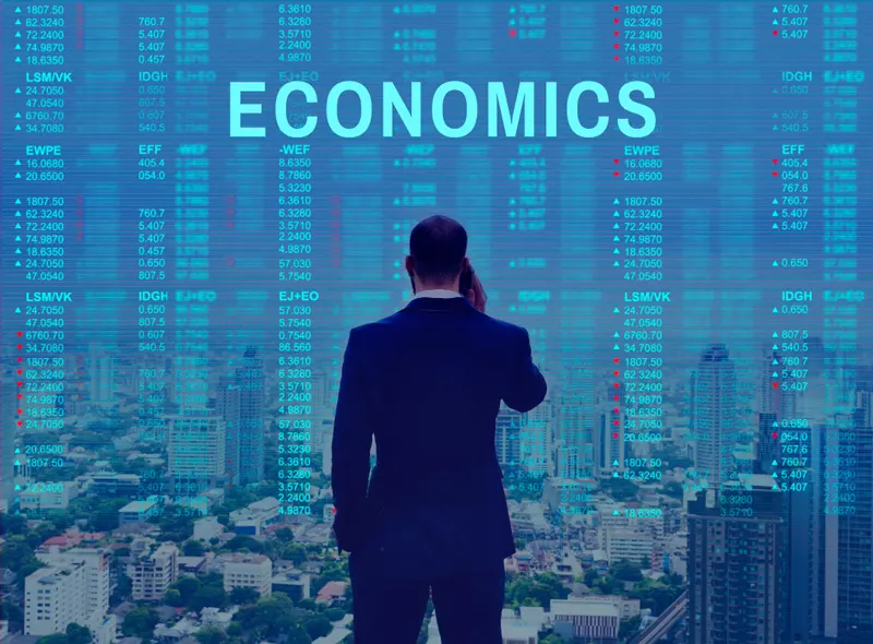 Businessman overlooking city skyline with 'ECONOMICS' overlay